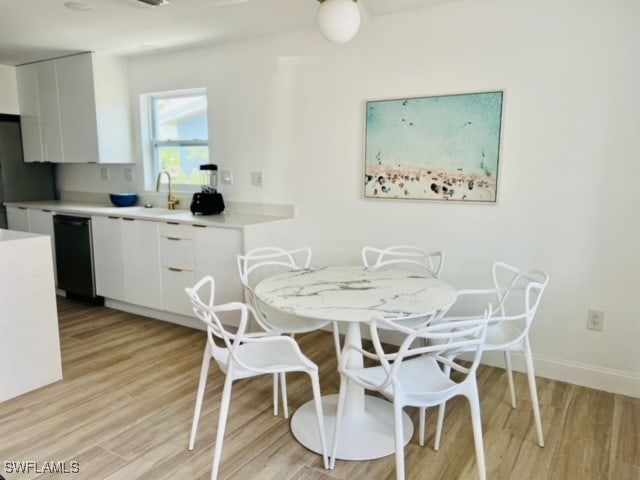 dining space with light hardwood / wood-style flooring and sink