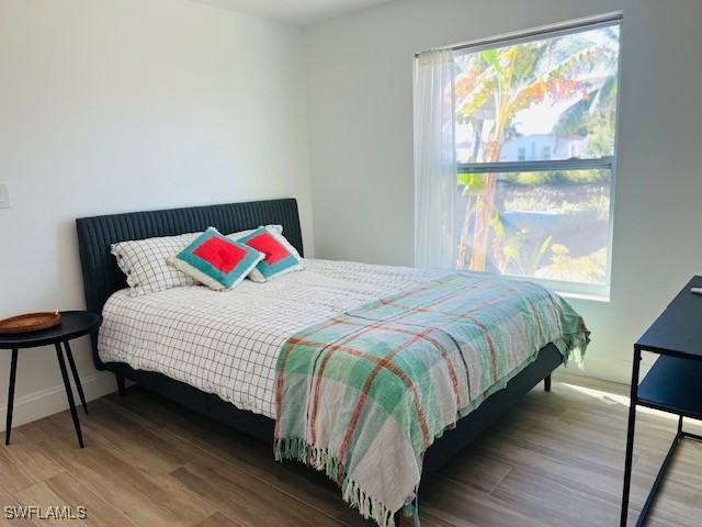 bedroom featuring wood-type flooring and multiple windows