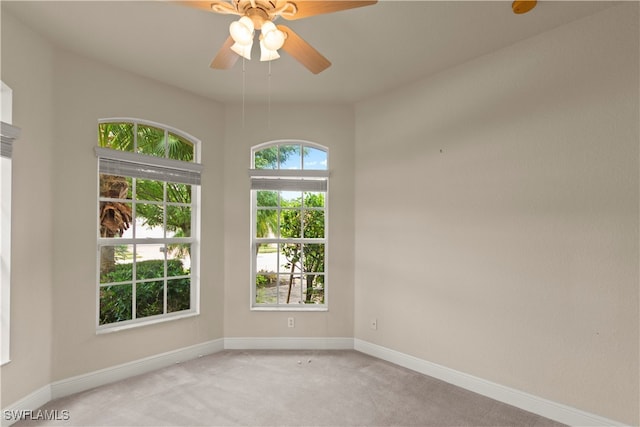 unfurnished room with baseboards, light colored carpet, and a ceiling fan