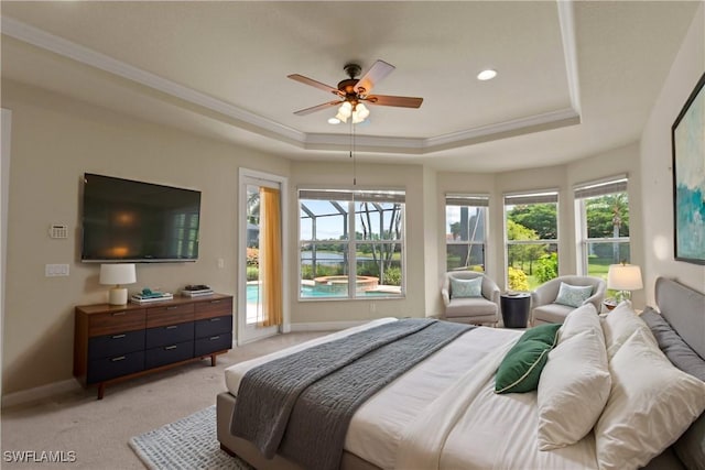 bedroom featuring multiple windows, crown molding, a tray ceiling, and access to outside