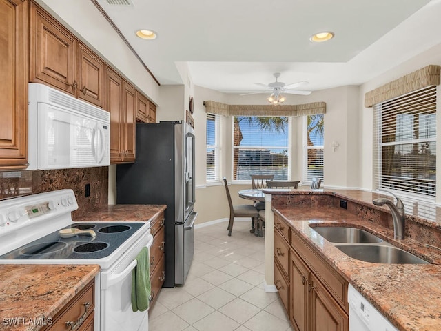 kitchen featuring white appliances, backsplash, sink, ceiling fan, and light tile patterned floors