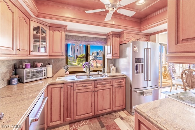 kitchen with ceiling fan, ornamental molding, sink, and appliances with stainless steel finishes