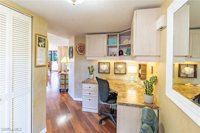 office space with built in desk and dark hardwood / wood-style floors