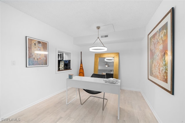 office space with light hardwood / wood-style floors and a textured ceiling