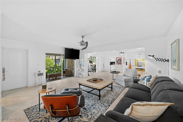 living room with crown molding, light hardwood / wood-style flooring, and a notable chandelier