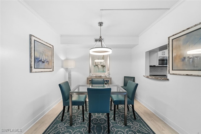 dining space with hardwood / wood-style floors and ornamental molding