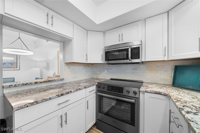 kitchen with decorative backsplash, stainless steel appliances, white cabinetry, and light stone counters