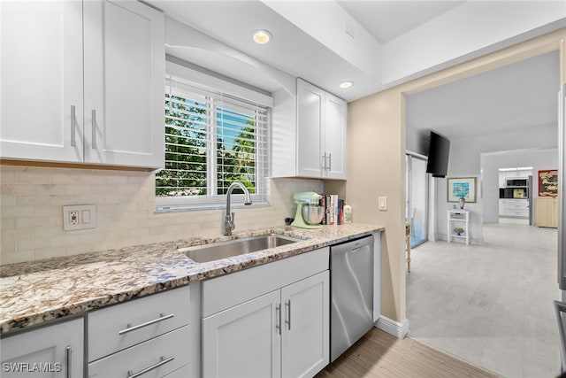 kitchen featuring white cabinetry, dishwasher, sink, tasteful backsplash, and light stone counters