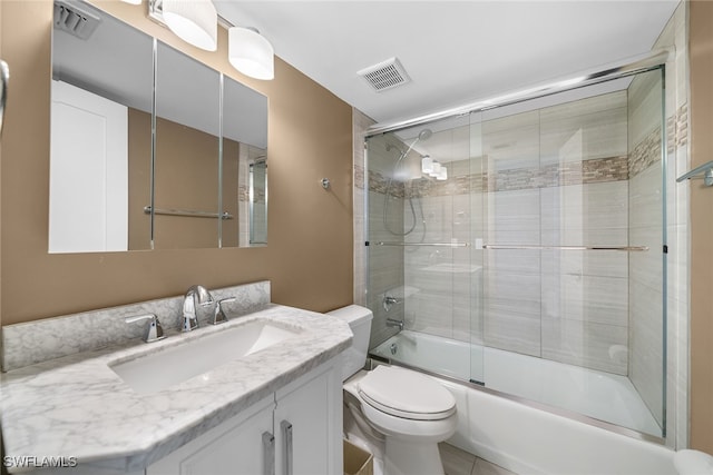 full bathroom with tile patterned floors, vanity, toilet, and combined bath / shower with glass door