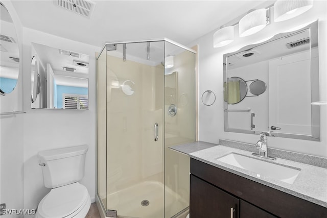 bathroom featuring vanity, toilet, and walk in shower