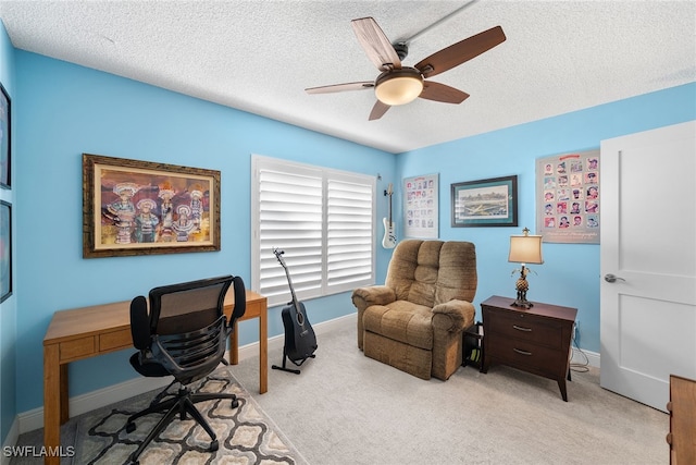 home office featuring a textured ceiling, ceiling fan, and light carpet