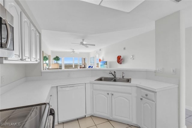 kitchen featuring light tile patterned flooring, dishwasher, range, white cabinets, and sink