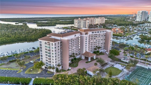 aerial view at dusk featuring a water view