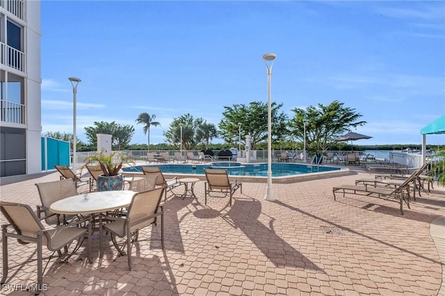 view of swimming pool featuring a patio area and a water view