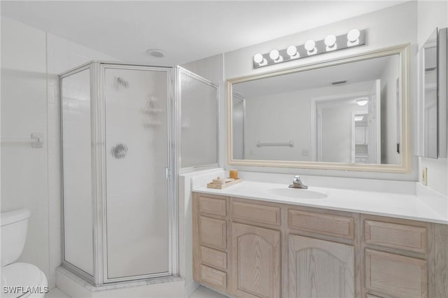 bathroom with toilet, a shower with door, and vanity