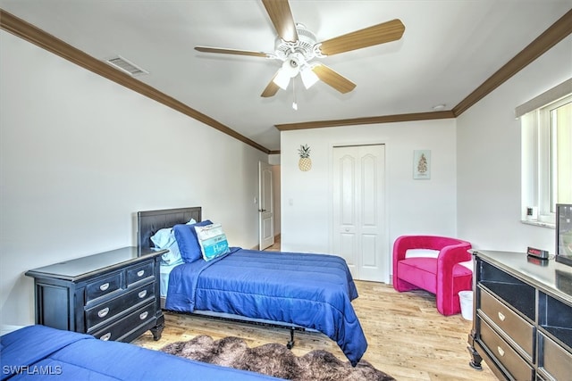 bedroom with a closet, ceiling fan, crown molding, and light hardwood / wood-style floors