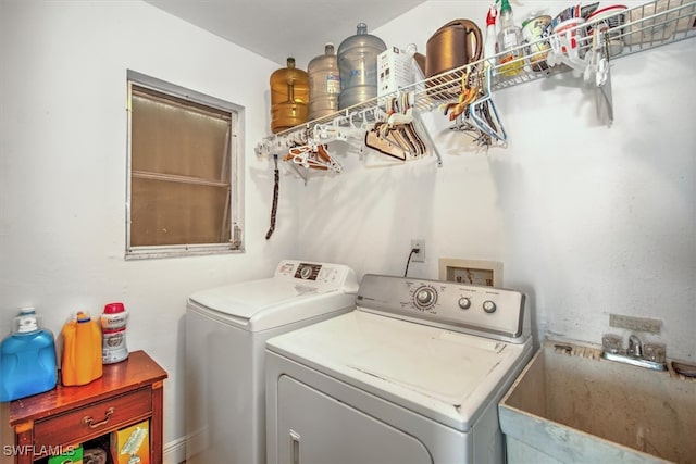 laundry area with washing machine and clothes dryer and sink