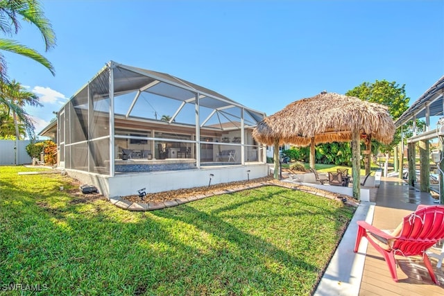 back of property with a lanai and a yard