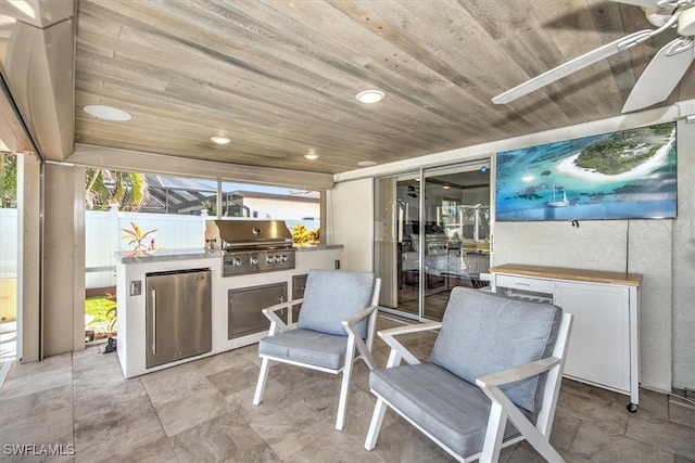 view of patio / terrace with grilling area, ceiling fan, and an outdoor kitchen