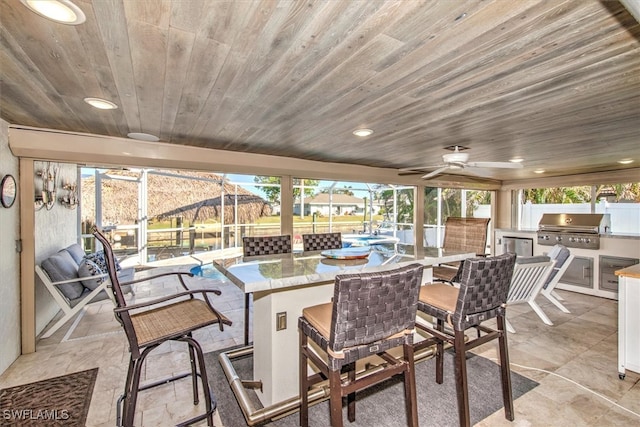 view of patio / terrace with area for grilling, ceiling fan, exterior bar, and grilling area