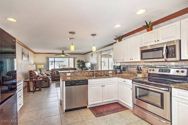 kitchen featuring stainless steel appliances, white cabinetry, and hanging light fixtures