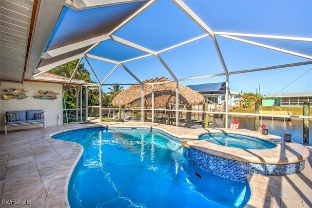 view of pool with glass enclosure, a water view, an in ground hot tub, and a patio