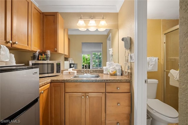 kitchen featuring a sink, brown cabinets, appliances with stainless steel finishes, and ornamental molding