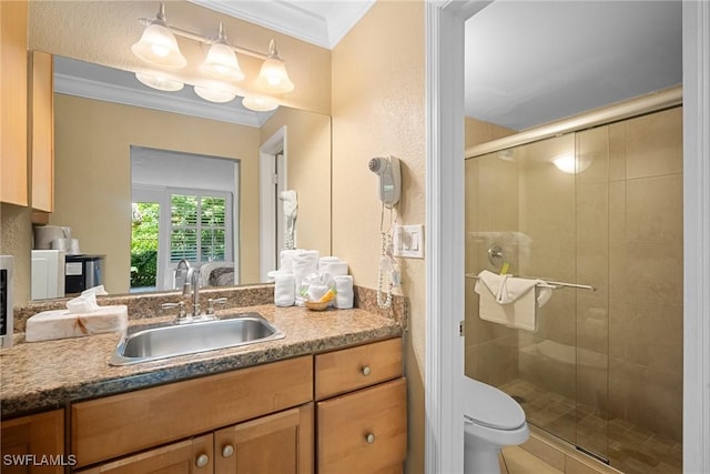 full bathroom featuring toilet, a stall shower, vanity, and crown molding