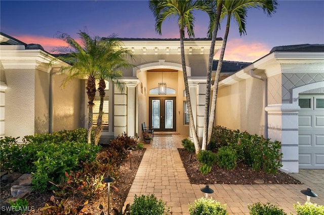 exterior entry at dusk featuring french doors