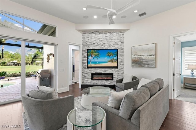 living room featuring a fireplace, dark hardwood / wood-style floors, vaulted ceiling, and ceiling fan