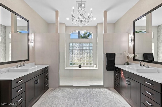 bathroom with tile patterned floors, a healthy amount of sunlight, a tile shower, and a notable chandelier