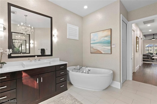 bathroom with hardwood / wood-style floors, vanity, a bathtub, and ceiling fan with notable chandelier