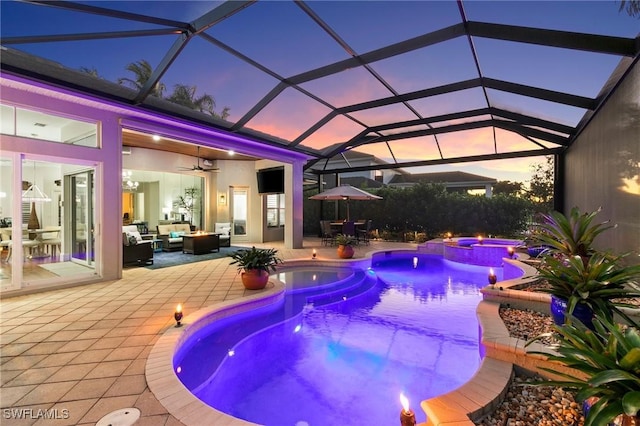 view of pool with an in ground hot tub, a lanai, an outdoor living space, ceiling fan, and a patio area