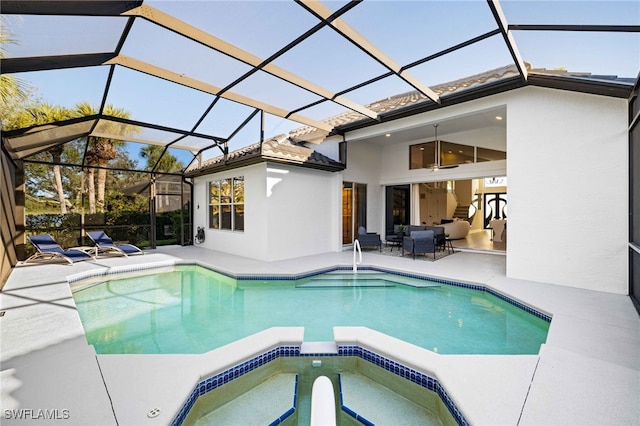 view of pool with glass enclosure, an in ground hot tub, and a patio area