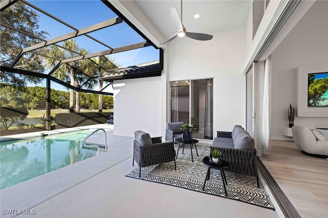 view of pool with a lanai, outdoor lounge area, ceiling fan, and a patio