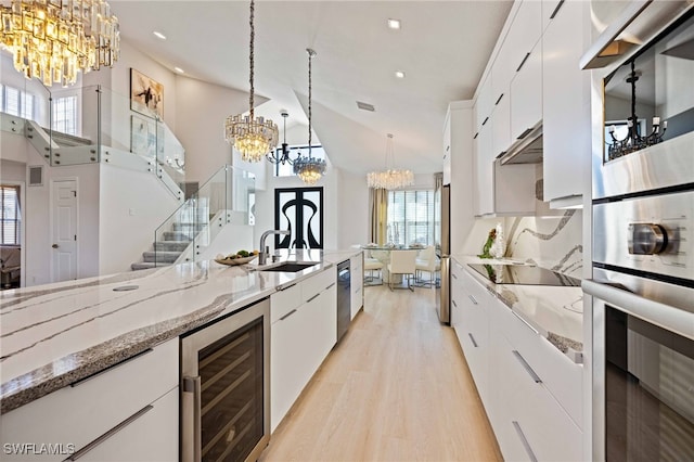 kitchen featuring white cabinets, a wealth of natural light, and beverage cooler