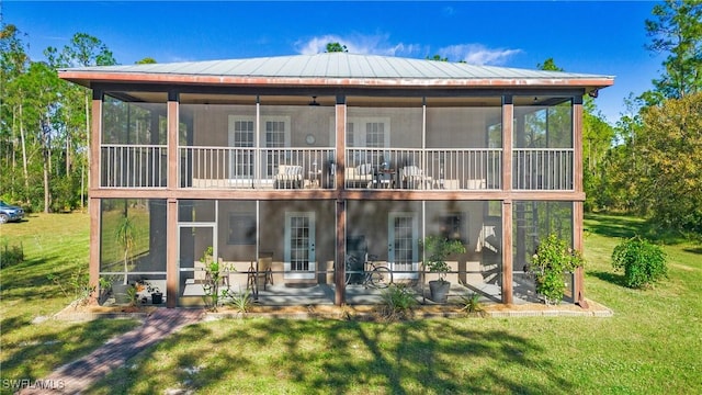 rear view of property with a lawn, a sunroom, and a patio area