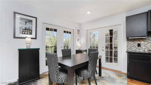 dining space with french doors and light hardwood / wood-style floors