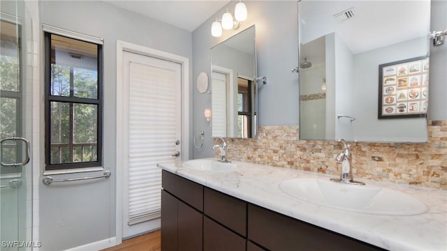 bathroom featuring decorative backsplash, hardwood / wood-style floors, vanity, and walk in shower