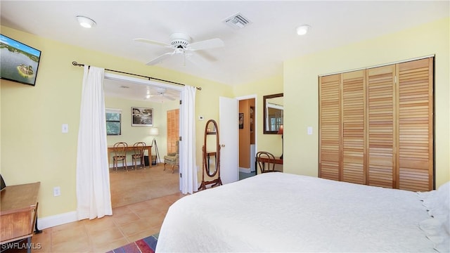 bedroom with ceiling fan, a closet, and light tile patterned floors