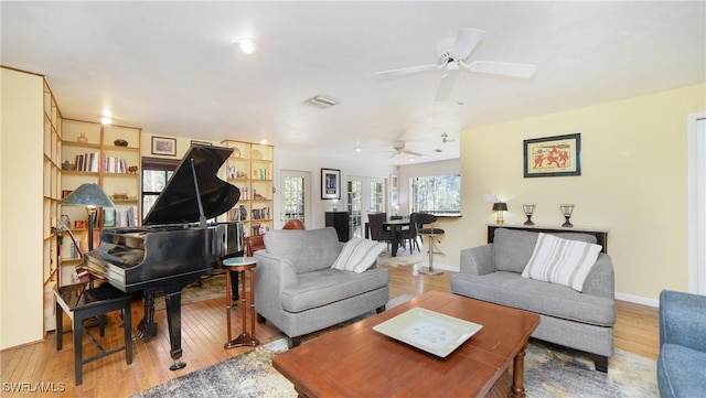 living room with ceiling fan and light wood-type flooring