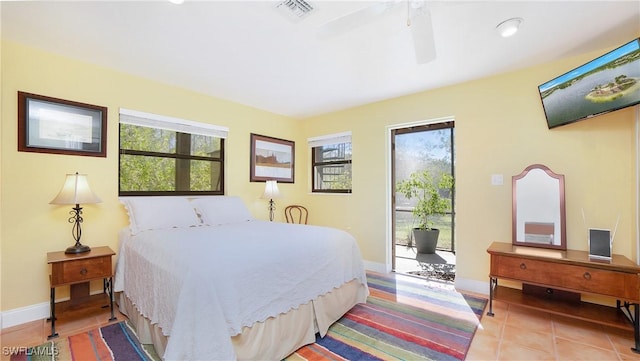 tiled bedroom with access to exterior, multiple windows, and ceiling fan