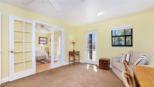 sitting room featuring light carpet and french doors