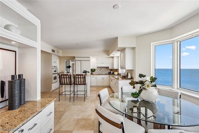 dining space featuring a water view and sink