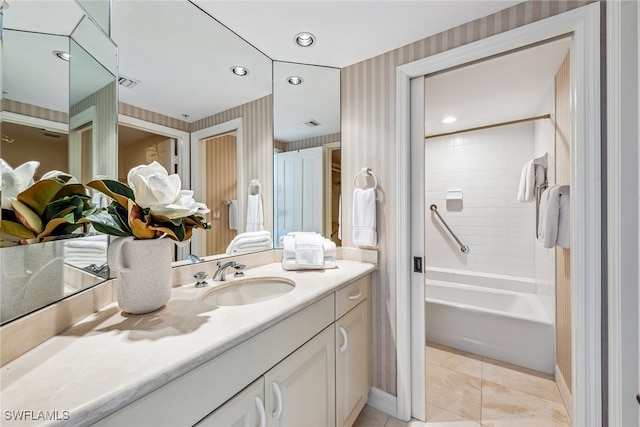 bathroom with tile patterned flooring, vanity, and tiled shower / bath