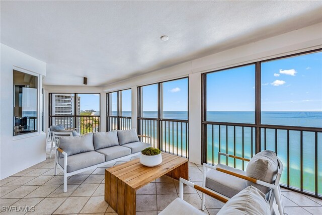 living room featuring light tile patterned floors and a water view