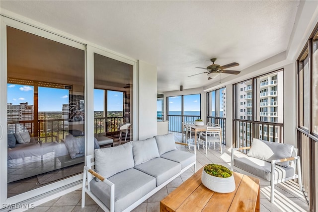 sunroom / solarium with a water view and ceiling fan