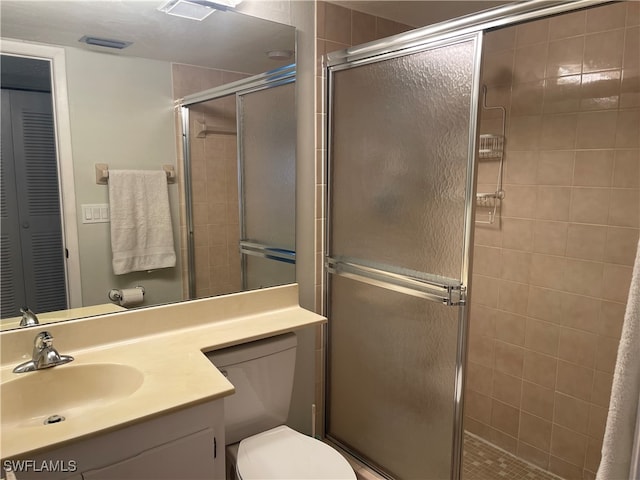 bathroom featuring vanity, toilet, and walk in shower