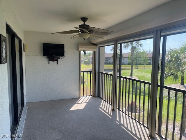 unfurnished sunroom with ceiling fan