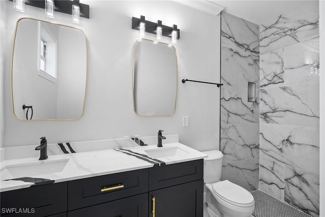 bathroom with toilet, a tile shower, and vanity